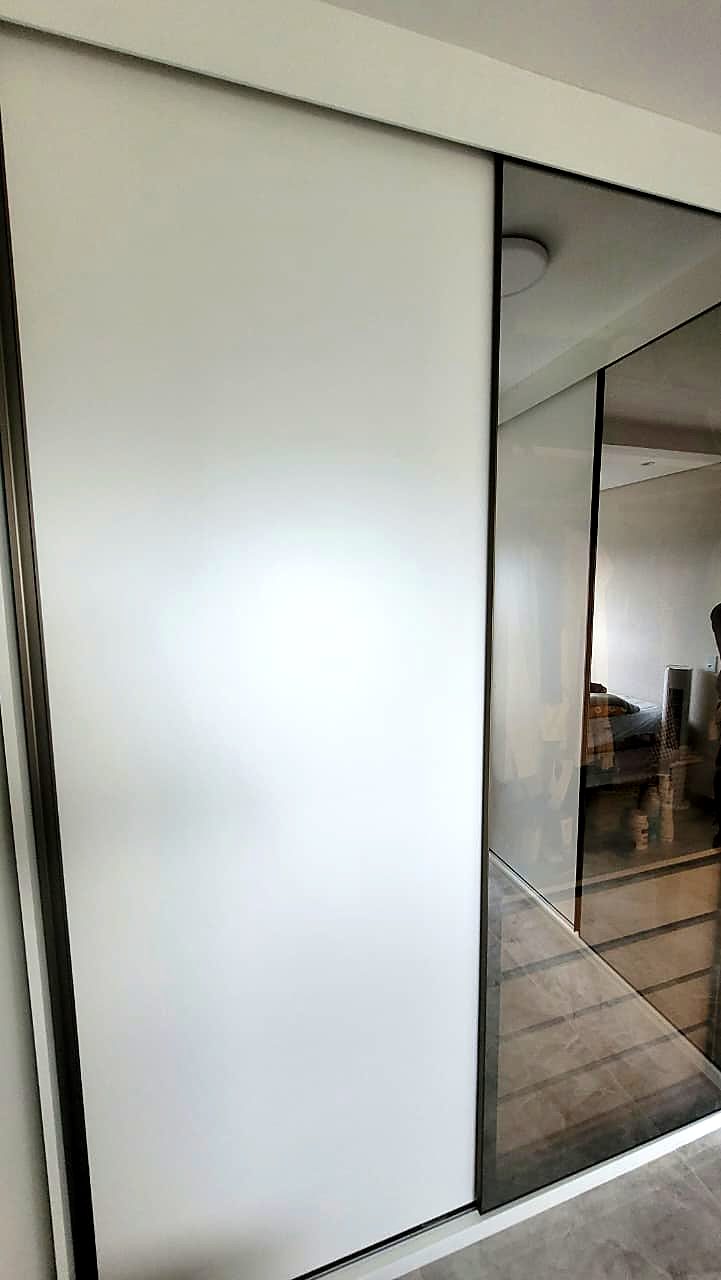 Armário com portas de correr branca e espelho