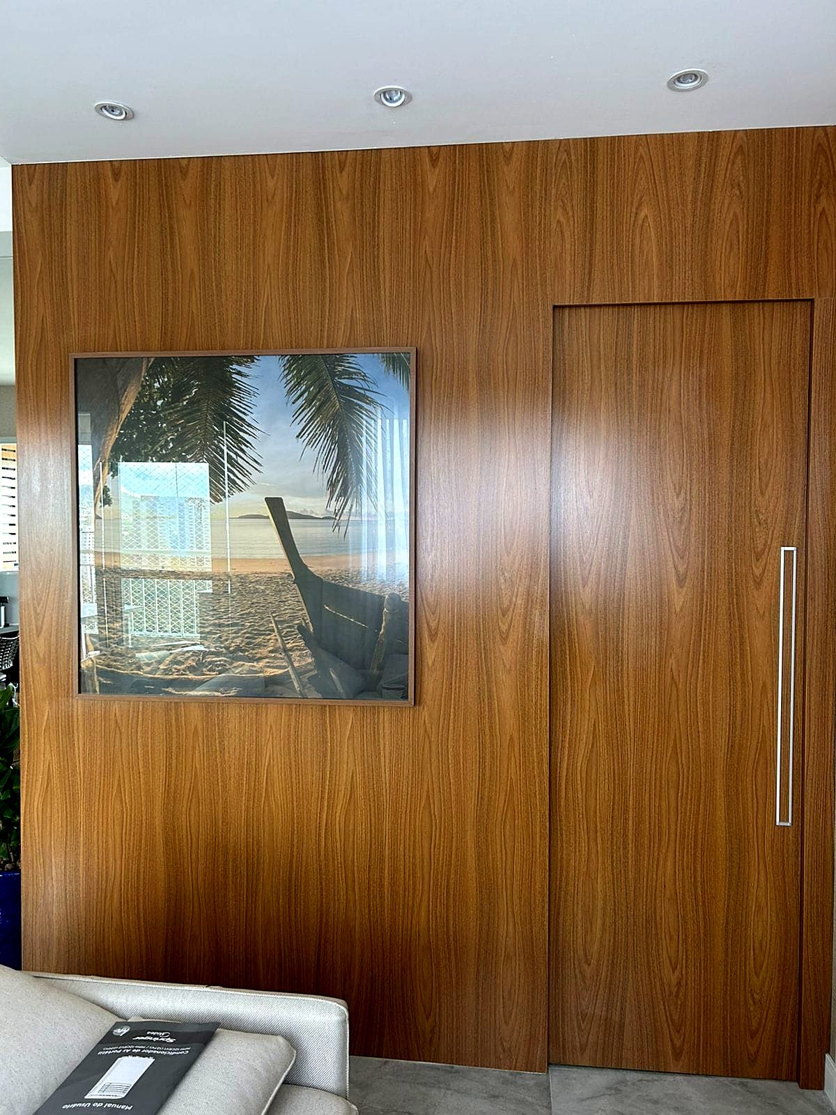 Painel de madeira com porta oculta no living