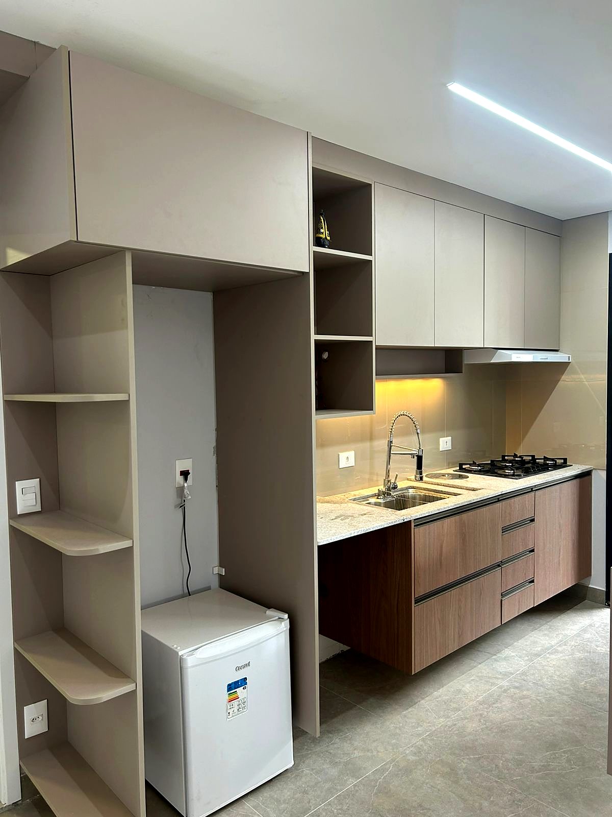 Cozinha compacta planejada com nicho para frigobar e prateleiras curvas