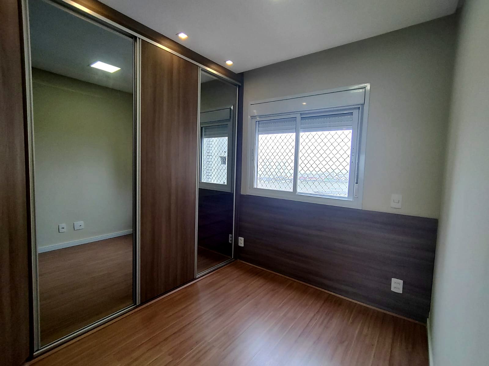 Dormitório com guarda-roupa de portas espelhadas