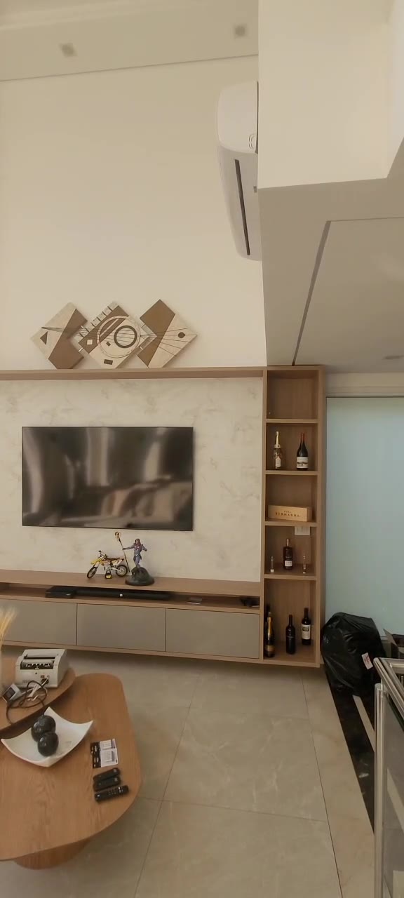 Living com painel de TV e ripado em madeira