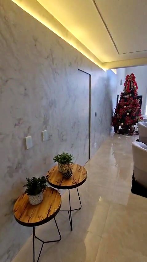 Parede revestida com porta oculta e sanca de LED em casa no Alphaville Residencial 11